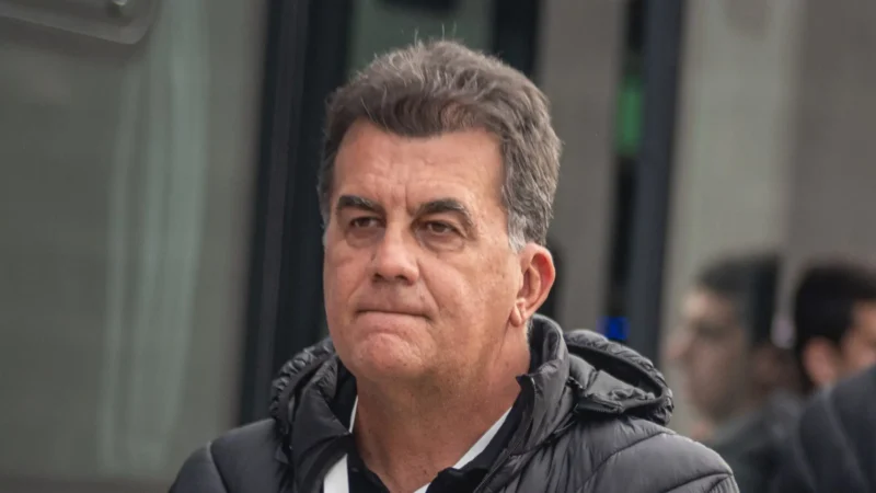Fábio Mota, presidente do Vitória, em expressão tensa na beira do campo com a camisa rubro-negra ao fundo